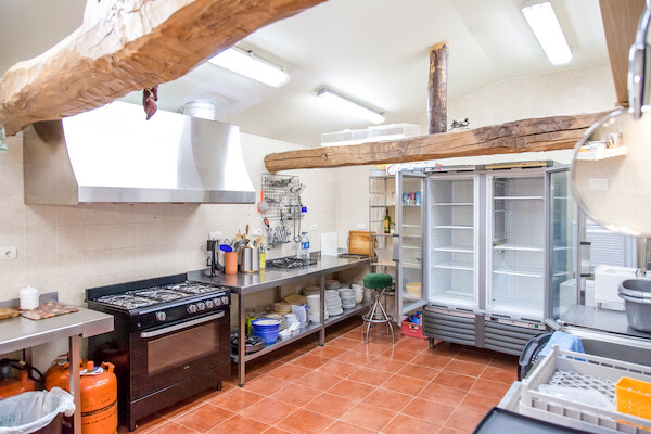 Cocina industrial totalmente equipada con fogones y grandes neveras para grupos en Pariseo