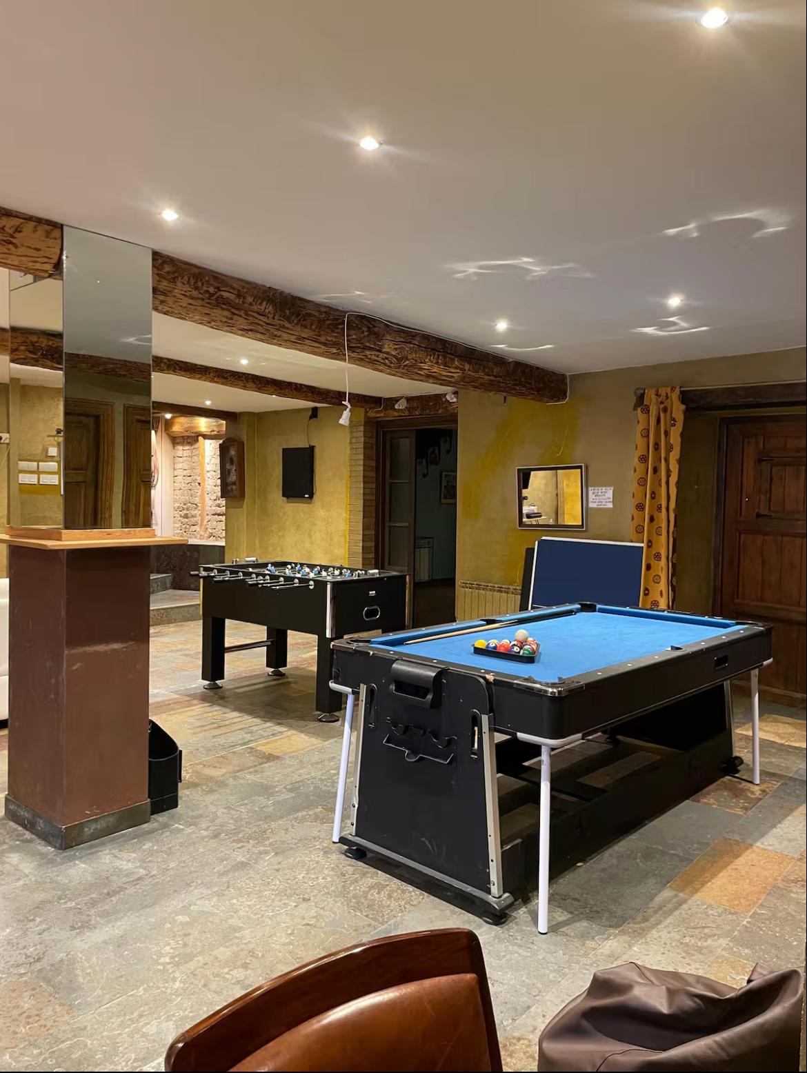 Sala de juegos con mesa de billar y futbolín para el entretenimiento de grandes grupos