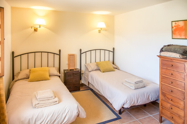 Dormitorio luminoso con paredes en tono amarillo y cama doble en la estancia Pariseo