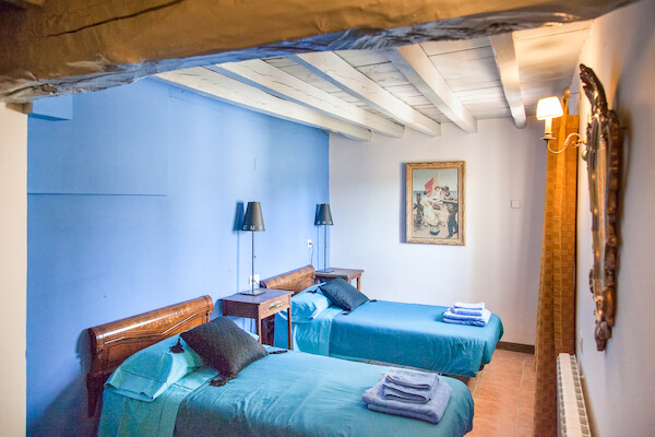 Habitación decorada en tonos azules con mobiliario clásico de madera para un descanso tranquilo